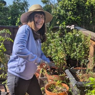 Deirdre Lehman gardening with a hat on